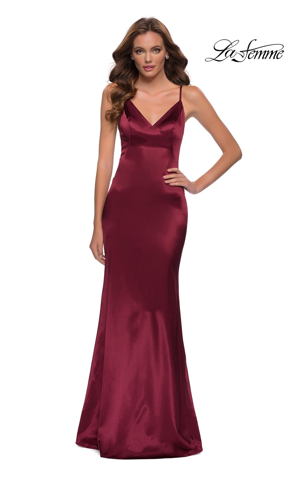 Woman wearing the Long Prom Dress: La Femme 29960 in burgundy satin with a sleeveless, fitted sheath skirt and v-neckline, posing against a white background.